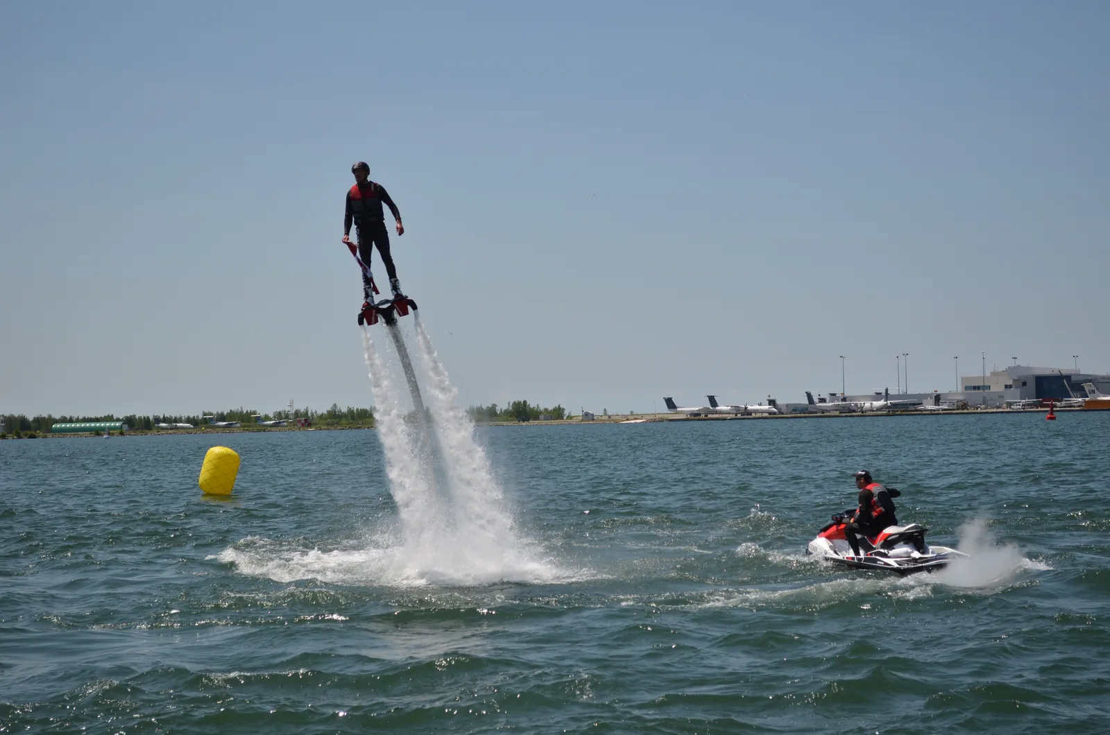 En flyboarddemonstration vid Torontos strand med vattenstrålar under fötterna