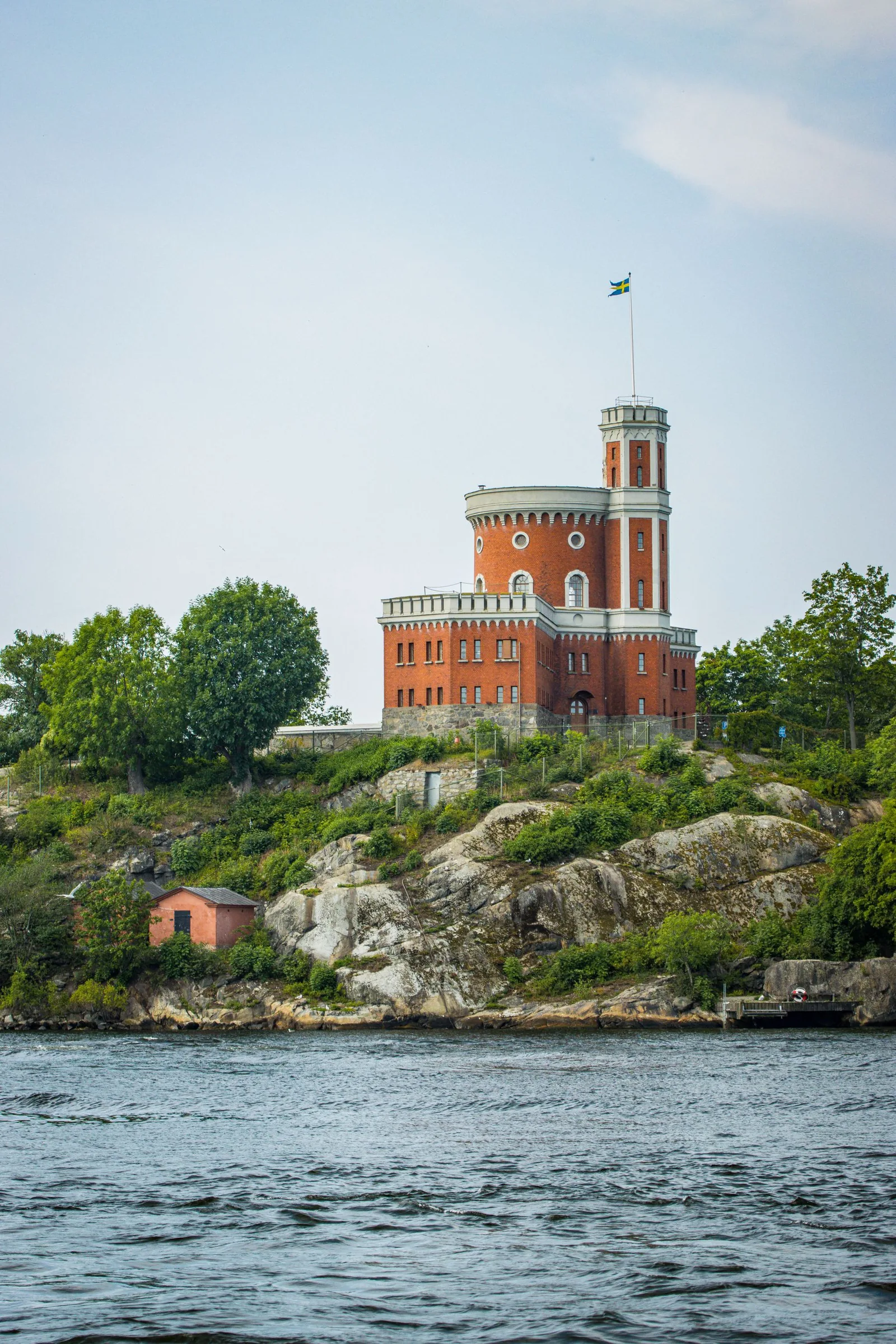 Vaxholms kastell med det svenska flaggspelet över skärgårdsvattnet